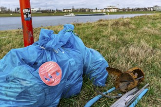 The Rhine near Düsseldorf, sacks of rubbish collected in the Rhine meadows and waiting to be taken