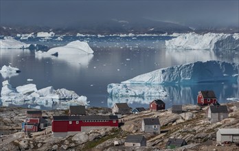 Large icebergs floating in fjord behind Inuit settlement Tiniteqilaaq, Sermilik Fjord, East