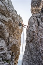 Climber on a climbing tour, abseiling, alpine climbing, crossing the Kampenwand, Chiemgau, Bavaria,