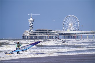 The pier and Ferris wheel at Scheveningen beach, strong swell, windsurfers, Netherlands