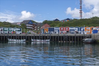 Colourful lobster shacks on the harbour promenade, Börteboote, offshore island Helgoland, blue sky,