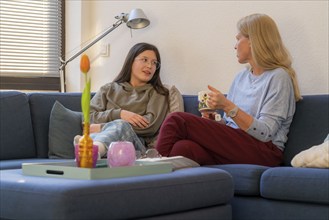 Mother and daughter, teenage, 13 years old, in a confidential conversation, at home