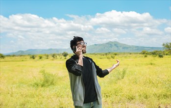 Happy people talking on the cell phone in the field. Man calling on the phone in the field, A man