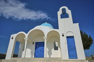 White church with blue doors and a bell against a blue sky, Church of Profitis Ilias, above Nikia,