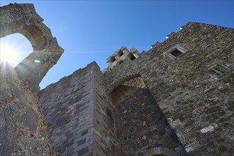 Historic ruin with stone structure and sun rays in the background, Agiou Theologou Monastery, St