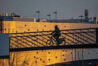 Cyclist on a bridge over Segerothstraße, in Essen, behind Limbecker Platz shopping centre