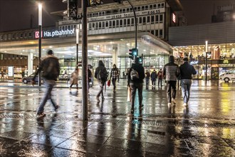 Passers-by at a pedestrian crossing, at the main railway station, rainy weather, city centre, in