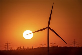 Wind turbine of the Emschergenossenschaft, view to the west, in Essen, sunset, behind the blast