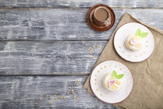 Decorated cake with milk and coconut cream with cup of coffee on a gray wooden background and linen