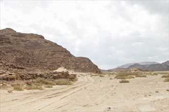 Desert, red mountains, rocks and cloudy sky. Egypt, the Sinai Peninsula, Dahab