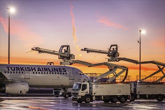 Frost at the airport, a Turkish Airlines aircraft is de-iced in front of sunrise. Airbus A321-231,