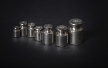 A set of small metal weights on a gray background