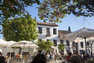 People sitting outside cafes historic square Placeta de San Miguel Bajo in the Albaicin district,