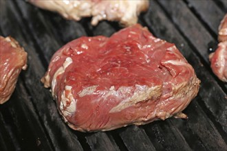 Raw steak on the grill