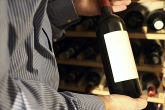 Symbolic image: Sommelier presents a bottle of red wine