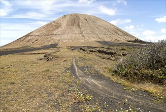 Volcano cone and black volcanic soil farmland, near Tinajo, Lanzarote, Canary Islands, Spain,