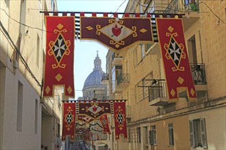 Flags decorate steep historic street in city centre of Valletta, Malta, Europe