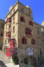 Red balconies and shutters historic building in city centre of Valletta, Malta, Europe