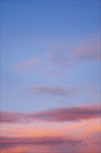 Blue sky with pink-coloured clouds at sunset