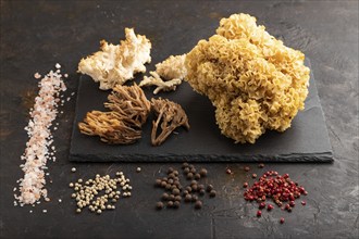 Raw Sparassis (Cauliflower Mushroom), Hericium, Clavaria (coral mushroom) on black concrete