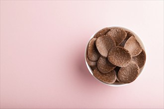 Chocolate chips with caramel on pink pastel background. top view, flat lay, copy space