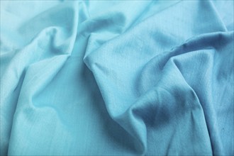 Fragment of cotton blue tissue. Side view, natural textile background and texture. wave concept,