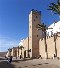 People walking outside medina walls, L'Horloge d'Essaouira, Essaouira, Morocco, north Africa,