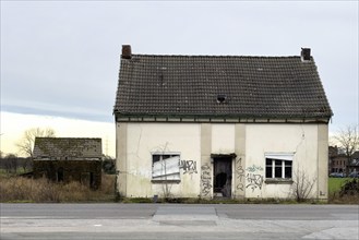 Abandoned house junk property on country road, on house wall graffiti by sprayer hate message