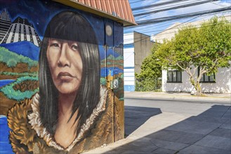 Colourful graffito with the image of an indigenous woman, street art in the city of Punta Arenas,