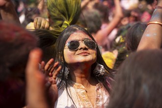 A girl dancing in the beat of music as she celebrate Holi on a street, the Hindu spring festival of