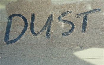 The word 'DUST' written on car rear windscreen following Saharan sand deposited in England by