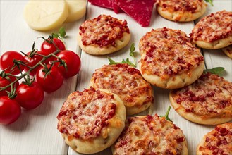 Mini pizzas, salami with mozzarella cheese, on a white table, top view, no people