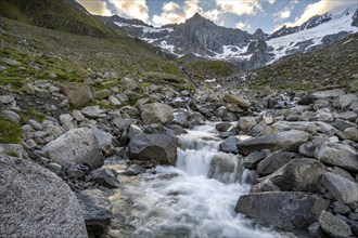 Mountain stream Furtschaglbach at sunrise, long exposure, rocky mountains behind, summit