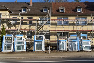 Energy-efficient refurbishment of residential buildings, older apartment block is scaffolded, gets