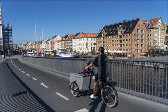 Cyclists on the Inderhavnsbroen cycle and footpath bridge, over the harbour, at Nyhavn, Copenhagen