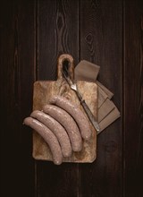 Raw sausages in English with bacon, for grilling, on a cutting board, top view, no people