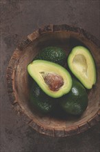 Fresh, sliced avocado, in a wooden plate, top view, food background, concept, food styling