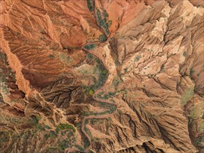 Eroded mountain landscape, top-down, canyon with red and orange rock formations, aerial view,