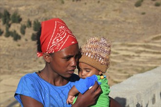 Young mother carries little boy in her arms, Ethiopia, Africa