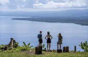 Three tourists look out over the South Pacific and rainforest, Osa Peninsula, Punterenas Province,