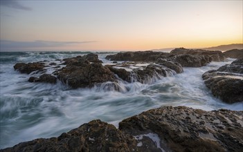 Waves washing over rocks by the sea, long exposure, coastal landscape at sunset, Playa Cocalito,