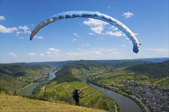 A paraglider takes off over a picturesque river landscape under a blue sky, paragliding, Bremm,