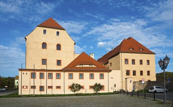 Medieval castle with tiled roof and many windows under a blue sky on a sunny day, castle, today