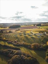 Landscape with meadows and fields at sunset, surrounded by hills and clouds, Horb, Solar Park,