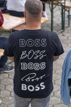 Man with T-shirt, on it the name Boss, brand name in different fonts