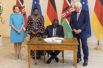 William Samoei Ruto (President of the Republic of Kenya) signing the guest book, behind him Elke