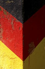 The colours black, red and gold on an old GDR border column, Haltern am See, North