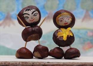 Two cute chestnut figures in front of a painted background, North Rhine-Westphalia, Germany, Europe