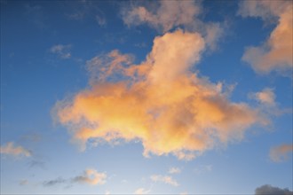 Orange spring clouds adorn the blue morning sky at sunrise