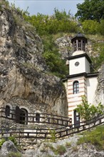 Small church with bell tower in a rocky environment, Bulgarian Orthodox cave monastery, rock